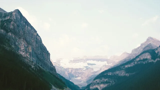 Un lago di montagna fra due versanti innevati.