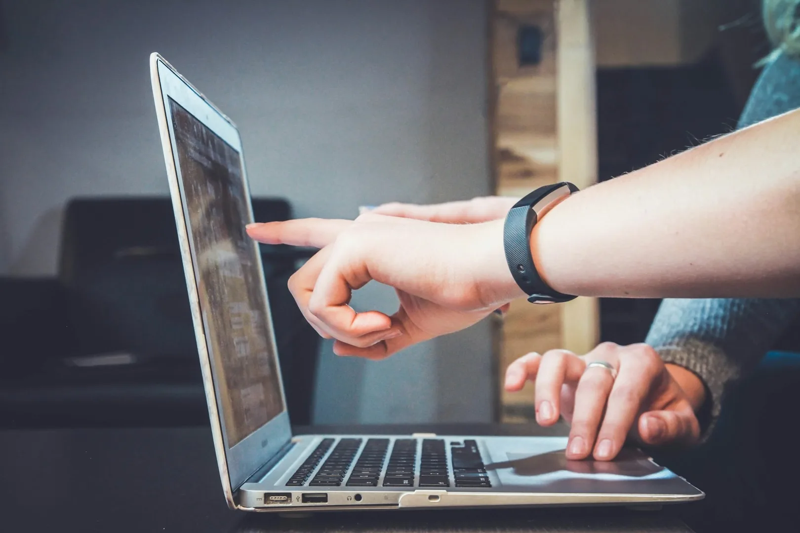 Le mani di una persona su un computer portatile, con lo schermo illuminato.