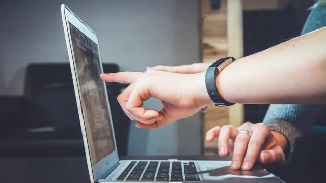 Le mani di una persona su un computer portatile, con lo schermo illuminato.